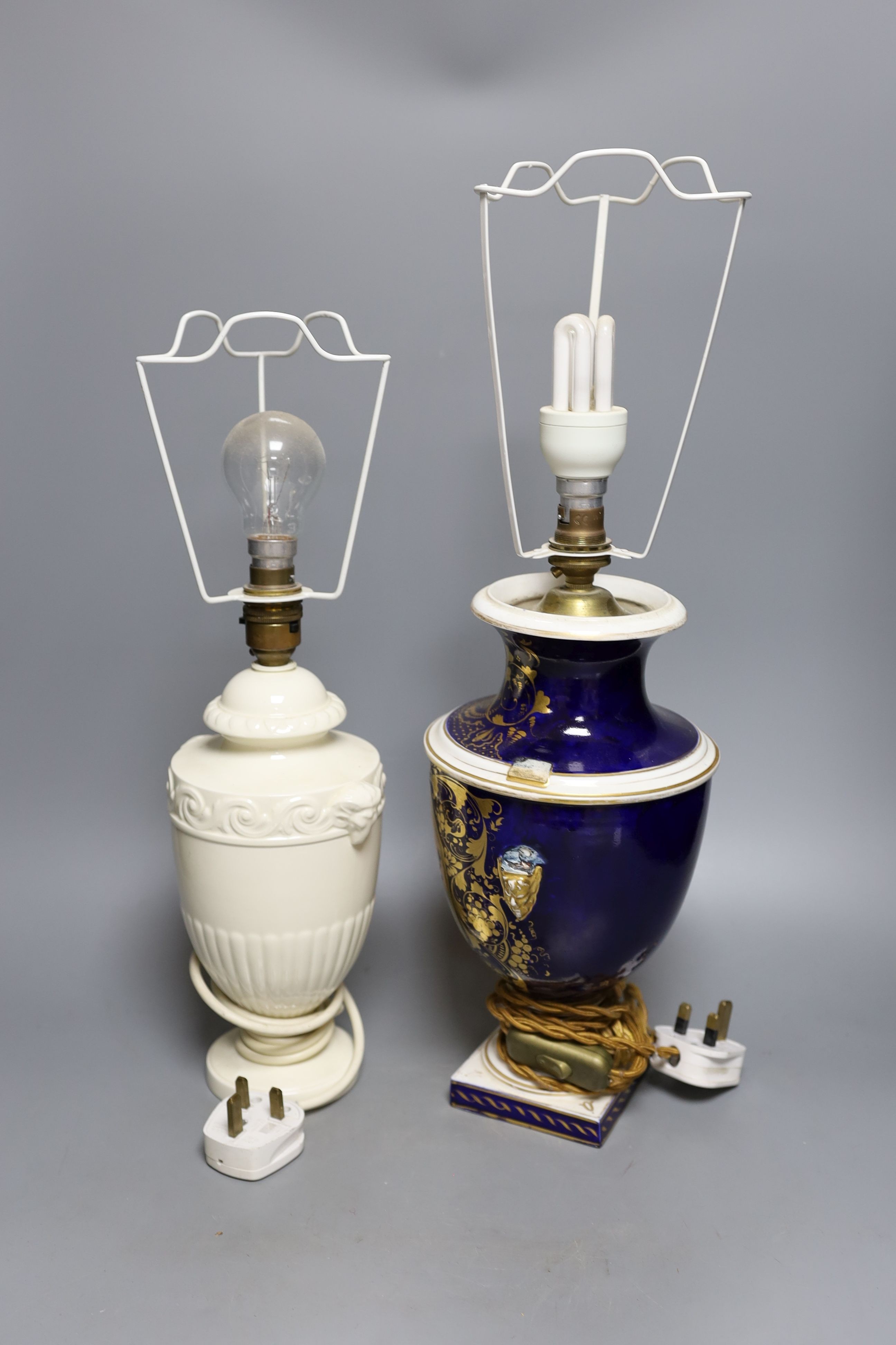 A Derby gilt and floral decorated lamp and Wedgwood lamp, tallest 30 cms high.